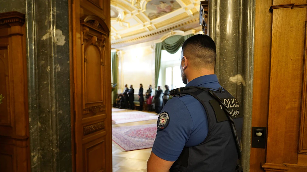 A fedpol police security officer monitors the entrance to the lobby in the Parliament Building.